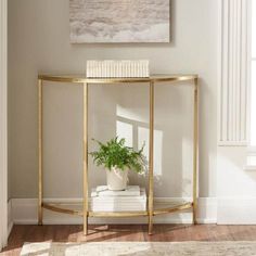 a white and gold console table with a potted plant on it in front of a window