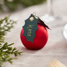 Dress your table in style this Christmas with these stunning red sateen finish Glass Bauble Christmas Table Place Card Holders. A great way to ensure your guests are seated in the perfect place around your table! Simply write your guest's name on the green paper holly leaf and place the baubles around your table! The unique design is sure to be loved by all. Each pack contains 6x Glass Bauble Christmas Place card Holders measuring 1.5in (D). Christmas Place Card Holders, Festive Dinner Table, Advent Calendar Boxes, Christmas Place Settings, Christmas Place Cards, Christmas Dinner Table, Christmas Bunting, Christmas Place, Alice Blue