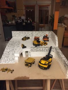 there are construction vehicles on the table in the room that's being worked on