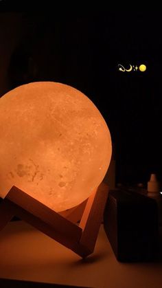 an illuminated lamp sitting on top of a wooden stand