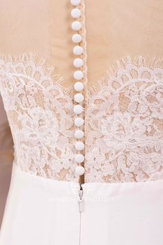 the back of a wedding dress with pearls on it