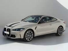 a white sports car parked in front of a gray wall