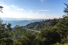 a scenic view from the top of a mountain with trees and mountains in the background