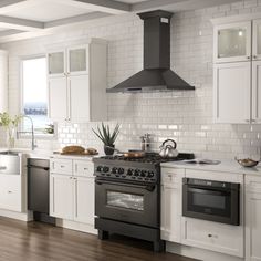 a kitchen with white cabinets and an oven in the center, along with wooden floors