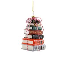 a christmas ornament made out of books is hanging from a string on a white background