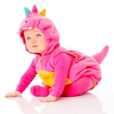 a baby in a pink dinosaur costume laying on the ground