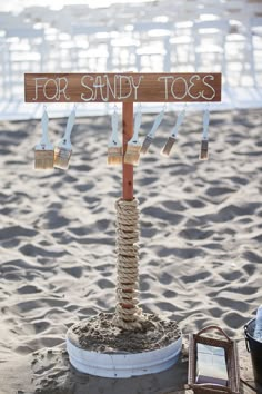 a wooden sign that says for sandy toes hanging from a rope with shoes on it