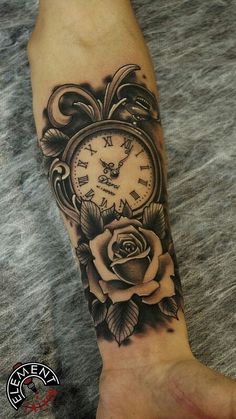 a person with a tattoo on their arm holding a clock