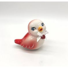 a glass figurine of a bird with a piece of paper in its beak