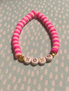 a pink and white beaded bracelet with gold letters that spell out the word love