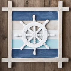 a ship wheel painted on the side of a wooden plank wall with blue and white stripes