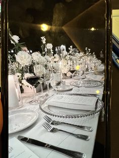 an image of a table setting with silverware and flowers in the centerpieces