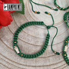 a green necklace with gold beads and an angel charm hanging from it's end