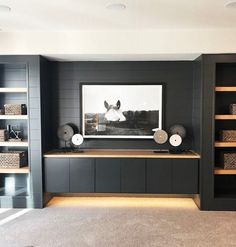 a living room with black and white decor on the wall, bookshelves and shelves