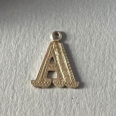 Lovely small sterling silver letter A initial charm for a pendant necklace (or perhaps a charm bracelet). A vintage piece in good condition with little to no visible surface wear. It measures roughly 1/2 inch by 1/2 inch and has decorative textured details for added visual interest. This would be a great gift for an A-plus friend or a wonderful addition to your everyday necklace stack. ---- All Your Name Here Vintage pieces have been hand-selected for their unique appeal and enduring quality. We do not test metal content of these pieces, but we will let you know if there is a maker's mark or a metal content mark on the piece itself. Cleaning and polishing is up to the purchaser (some folks like to retain the authentic vintage patina on an older piece). Sold as-is--please see photos or mess Monogram Pendant, Monogram Jewelry, Everyday Necklace, Initial Charm, Monogram Initials, Name Necklace, Favorite Jewelry, Initials, Bracelet