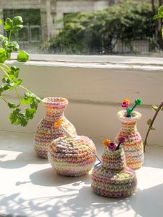 three crocheted vases sitting on a window sill