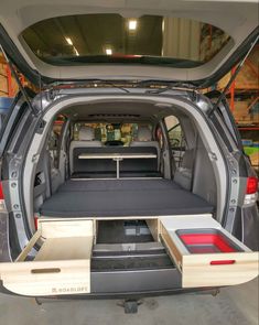 the back end of a van with its cargo compartment open and two drawers on each side