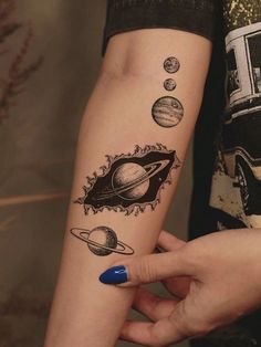 a woman's arm with different planets on it