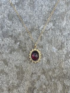 This necklace is handcrafted with an authentic 6x8mm garnet stone in a 16x11mm gold-plated stainless steel setting. The chain is 14k gold-filled and will not tarnish easily. The stone is AAA quality. This necklace is hypoallergenic. (Cadium free, lead free, and nickel safe) Garnet is an energizing stone that promotes passion and love.  The necklace comes in a ribbon-wrapped box, ready to be gifted. If you would like to leave a note for the recipient, you can do so during checkout. Gold Necklaces With Jewels In 14k Gold, Handmade Elegant Yellow Gold Birthstone Necklace, Gold Jewelry With Garnet Birthstone, Gold Garnet Gemstone Jewelry, Gold Necklaces With Gemstones In 14k Gold Filled, Gold Garnet Jewelry For Gifts, Dainty Brass Necklaces For Formal Occasions, Dainty Gold Ruby Jewelry, Gold Ruby Birthstone Jewelry