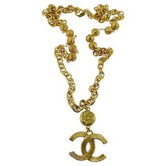 Chanel Vintage Gold Toned Logo Pendant Necklace | See more rare vintage Pendant Necklaces at https://www.1stdibs.com/jewelry/necklaces/pendant-necklaces Gold-tone Metal Necklace With Logo Plaque, Gold Chain Necklace With Gold-tone Logo, Gold Chain Necklace With Logo Plaque, Gold Metal Necklaces With Gold-tone Logo Plaque, Vintage Gold Necklace With Gold-tone Logo Plaque, Vintage Jewelry With Gold-tone Logo Plaque, Gold-tone Metal Chain Necklace With Logo Charm, Vintage Gold-tone Chain Necklace With Coin Pendant, Gold Metal Necklace With Logo Charm