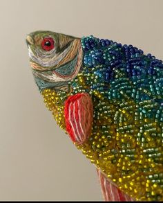 a colorful fish made out of beads on a white background