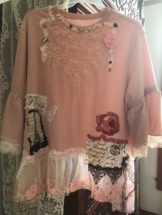 a pink shirt with lace and flowers on it