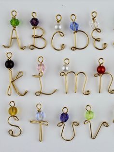 the letters and numbers are made out of gold wire with different colored glass beads on them