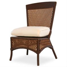 a brown wicker chair with a white pillow on it's seat cushion and back