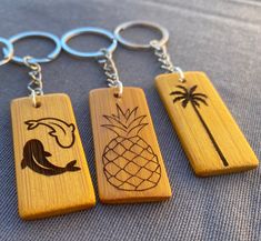 three wooden key chains with different designs on them