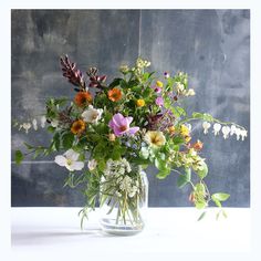 a vase filled with lots of different colored flowers