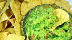 a glass bowl filled with guacamole and chips