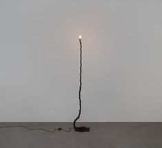 a light that is on top of a wooden pole in the middle of a floor