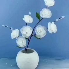 a white vase filled with flowers on top of a table