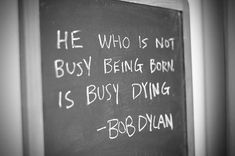 a chalkboard with writing on it that says he who is not busy being born is busy dying bob dlan