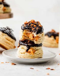 three desserts stacked on top of each other with chocolate drizzled on them