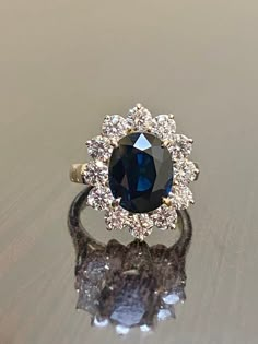 DeKara Designs Clearance Metal- 14K Yellow Gold, .583. Stones- Genuine Australian Oval Blue Sapphire 3.60-3.80 Carats, 12 Round Diamonds H-I Color SI1 Clarity, 1.50 Carats. Size- 3-12 Handmade 14K Yellow Gold Sapphire and Diamond Ring. This ring is inspired by Princess Diana and the Art Deco era with an enticing Australian fiery oval shaped midnight blue sapphire. The sapphire is professionally set in between four prongs. The sapphire has a halo of prong set 12 round diamonds surrounding them wh Diana Engagement Ring, Sapphire Halo Engagement Ring, Diana Ring, Blue Sapphire Engagement Ring, Diamond Princess, Expensive Jewelry Luxury, Vintage Sapphire, Sapphire Engagement Ring Blue, Etsy Wedding Rings