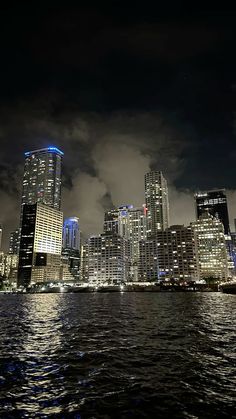 the city is lit up at night and it looks like they are floating in the water