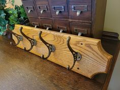 a wooden coat rack sitting on top of a table next to a vase filled with flowers