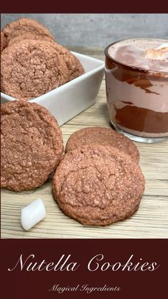 chocolate cookies with marshmallows next to it and a glass of hot cocoa