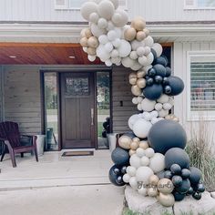 a bunch of balloons that are in front of a house with a door and chair