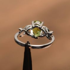 It is a natural peridot ring. The main stone is 7 mm*9 mm oval cut.weight about 1.99 carats. The basic metal is sterling silver and plated with rhodium. To change the metal to a solid gold (white/rose) or platinum is also available, please ask for a quotation if you want. You can also go to my shop Home for more elegant rings: https://www.etsy.com/shop/godjewelry?ref=hdr_shop_menu Peridot is August birthstone More peridot rings: https://www.etsy.com/shop/godjewelry?section_id=20709252 Customizat Peridot Rings, Peridot Engagement Ring, Engagement Ring Oval Cut, Peridot Engagement Rings, Elegant Rings, Engagement Ring Oval, August Birthstone, Peridot Ring, Engagement Rings Oval