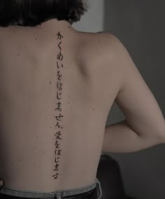 the back of a woman's body with writing on her upper and lower back