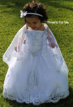 Our Virgin Mary Embroidered Baptism Collection is here!All our dresses are made here in the United States.A 3 pcs dress: includes dress, cape and headband.Our dresses are made of satin and organza.We use satin on our beautiful dresses and organza on capes.Dresses are true to size, corset on sides to adjust for perfect fit. A large Virgin Mary Embroidery on skirt of dressSpaghetti strap make our dresses fresh for any sunny summer baptism Hope you love it as much as we do!Sizes:12 monthsLength:25- Virgin Mary Embroidery, Mary Embroidery, Girl Baptism Party, White Baptism Dress, Vestido Charro, Bautizo Ideas, Baptism Dresses, Girls First Communion Dresses, Baby Baptism Dress