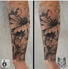 the arm is covered with black and white tattoos on it, while there are flowers