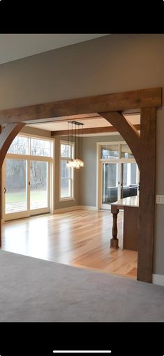 an empty living room with wooden beams and windows