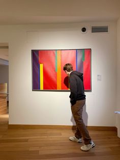 a man standing in front of a colorful painting