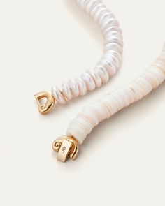 A series of sustainably-sourced shells and donut pearls encircle the neck in an elevated way, with a nautilus closure that can be worn in the front or the back.Using the foldover closure: Look for the JENNY BIRD logo on the flat bar. On one side, you’ll see a hinge, on the other side, you’ll see a tab. Gently pull the tab upward to open. To close, thread the tab closure through the opening, and press firmly to close. You will hear it click into place. 14K gold ion plated steelfreshwater pearlssh