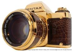 a gold camera with brown leather strap