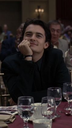 a man sitting at a table with wine glasses