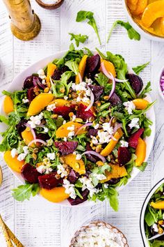 a salad with beets, oranges and feta cheese is on a white plate